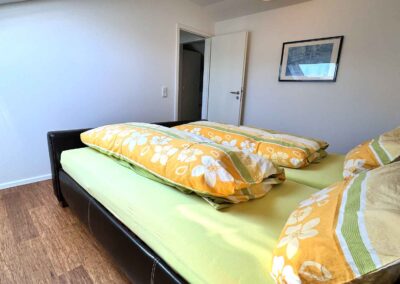 In der Ferienwohnung ist das Schlafzimmer mit großem Doppelbett, Der Boden ist aus Holzlaminat, welches sich auch im Wohnraum wiederfindet.